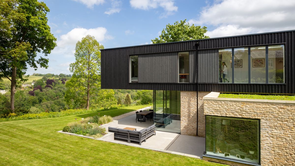 view of black timber and stone house with view over valley