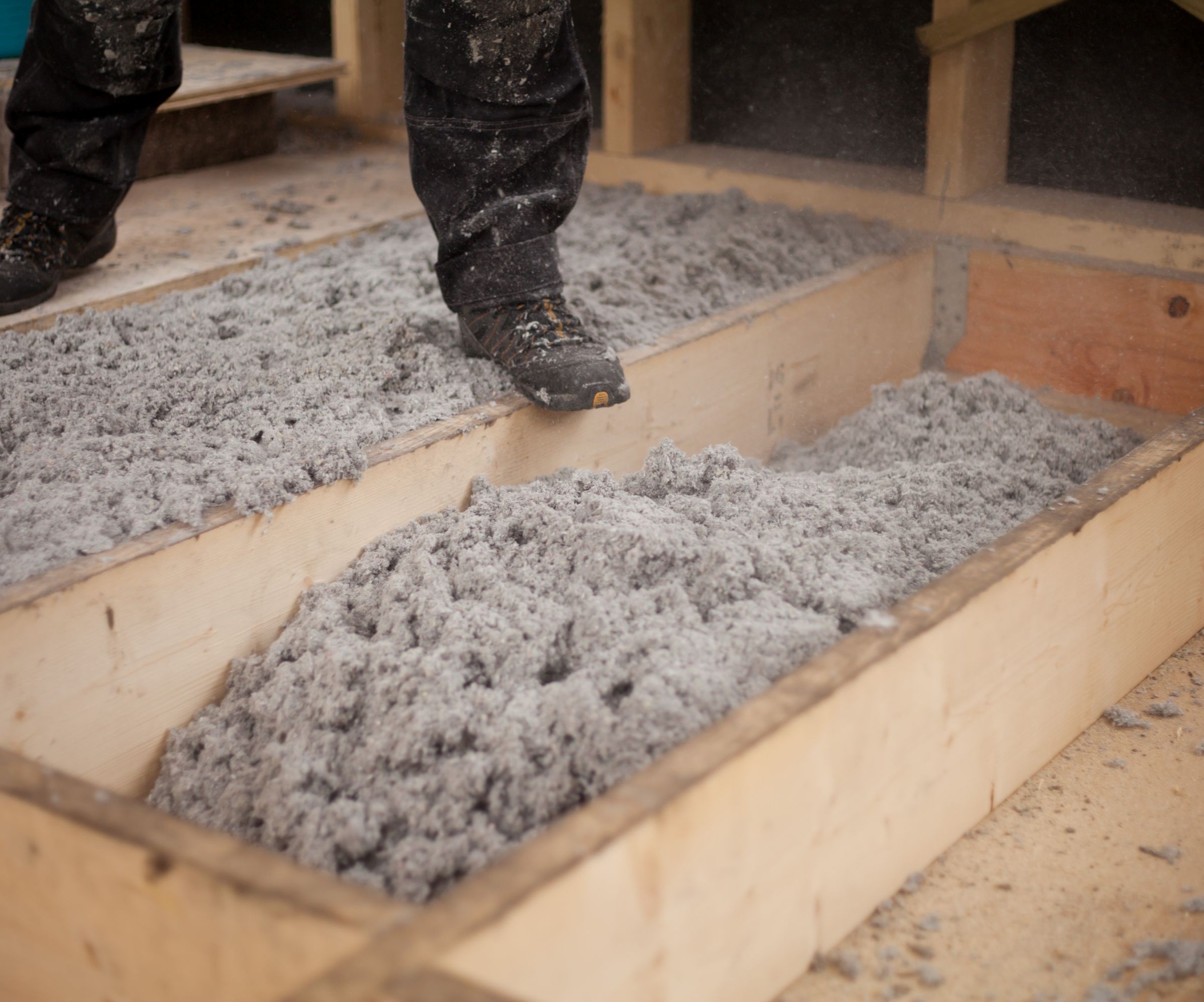 Pulped paper insulation inside the gaps in flooring joists