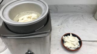 Cuisinart Pure Indulgence Ice Cream Maker making vanilla ice cream with a bowl of vanilla ice cream at the side