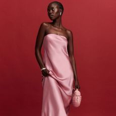 a model poses wearing a strapless pink satin dress