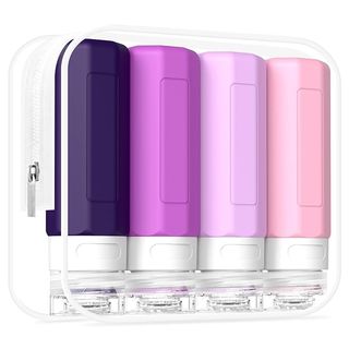 Four travel bottles in shades of purple inside a clear plastic carrying case