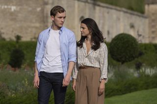 harry lawtey and marisa abela as robert and yasmin walking on the grounds of henry muck's estate in industry season 3