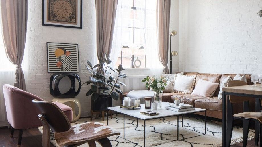 Living area with leather sofa on a white square rug on top of wooden floor