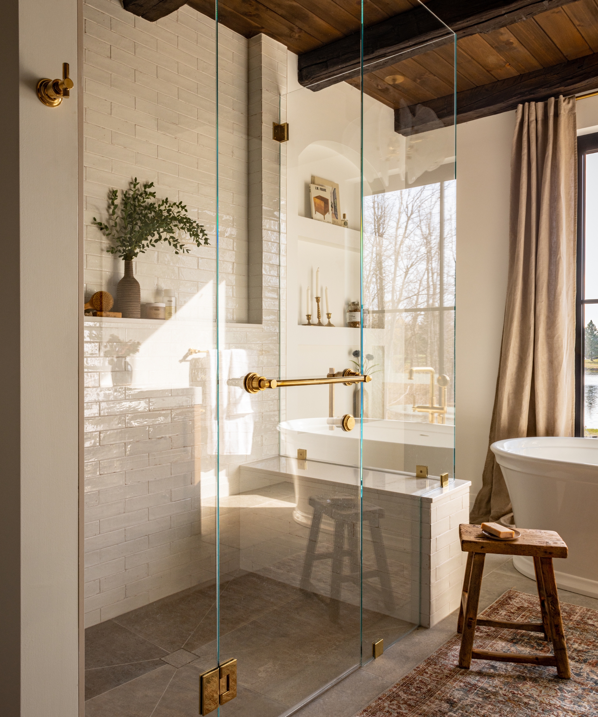 a large bathroom with wooden ceilings, a glass shower enclosure and a tiles bench seat