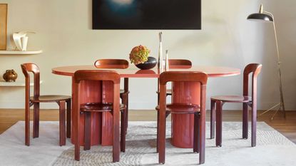 Orange lacquer dining table with lacquer chairs and large artwork
