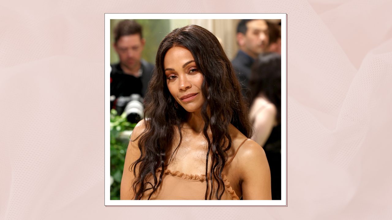 Zoe Saldaña is pictured with long, wavy brunette hair whilst attending The 2024 Met Gala Celebrating &quot;Sleeping Beauties: Reawakening Fashion&quot; at The Metropolitan Museum of Art on May 06, 2024 in New York City/ in a pastel pink template