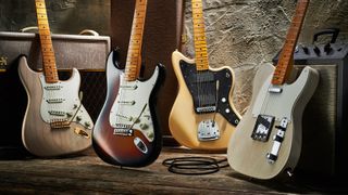 A group of Fender guitars leaning against various amplifiers