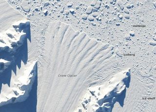 April 2002: The Crane glacier, which fed the Larsen B ice shelf, just weeks after Larsen B collapsed. The glacier is beginning to disintegrate, with cracks beginning to show along its fan-shaped edge.