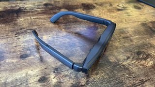 The TCL RayNeo Air 2 smart glasses on steel and wooden surfaces