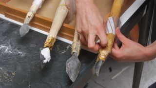 Four reconstructions of Stone Age projectile weapons with spear points and wooden staffs.