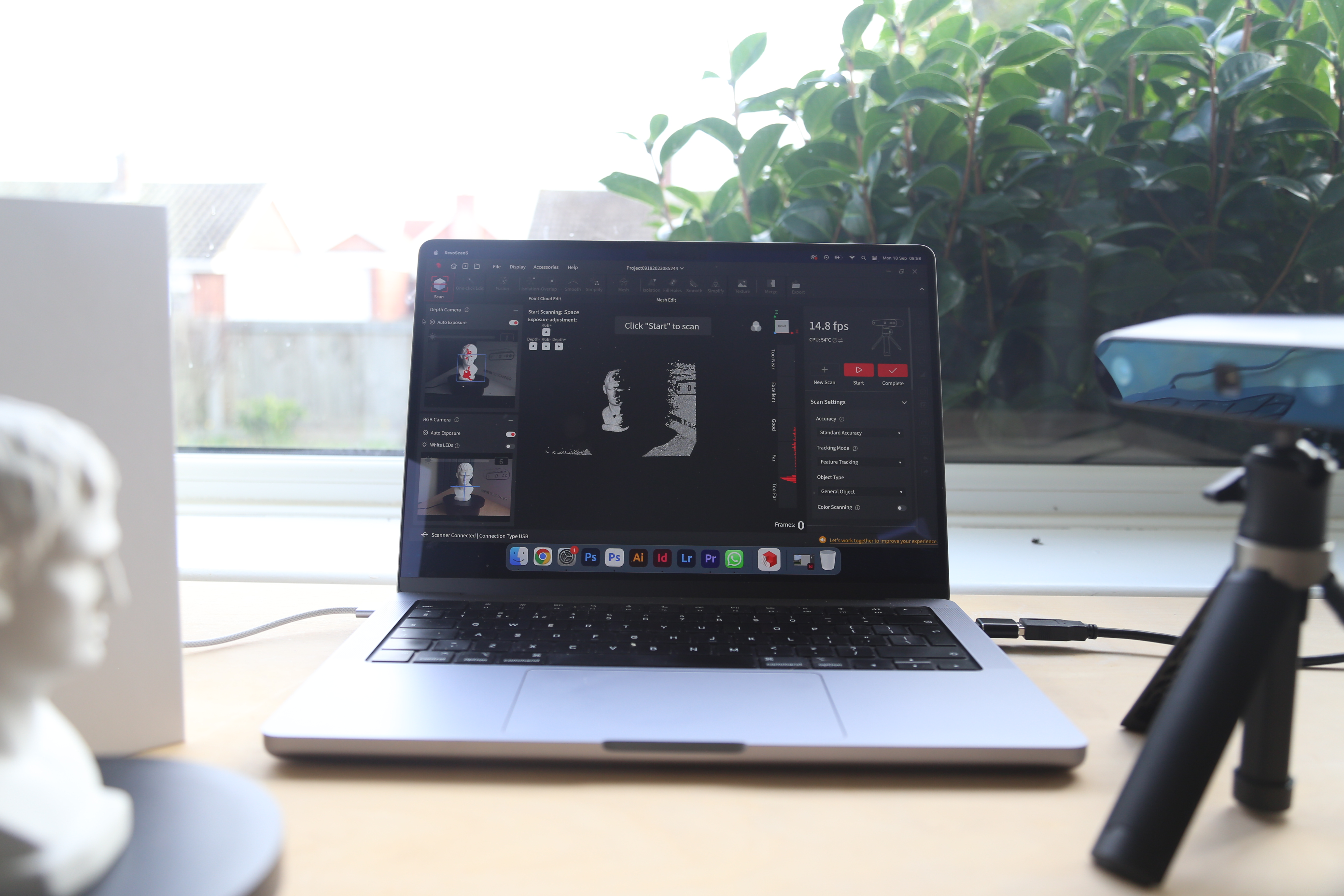 A Revopoint INSPIRE 3D Scanner on a desk, along with an object to scan and a laptop