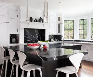 Black marble topped island in white kitchen