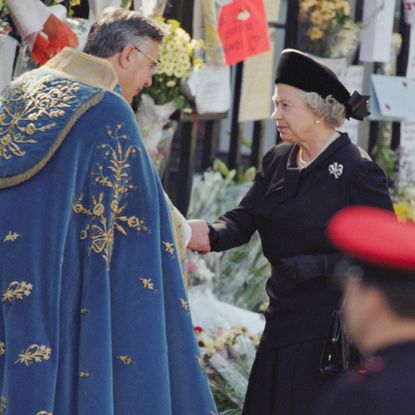 Queen Elizabeth shaking hands with a clergyman at Princess Diana's funeral