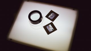 A pair of 35mm mounted slides and loupe on a lightbox