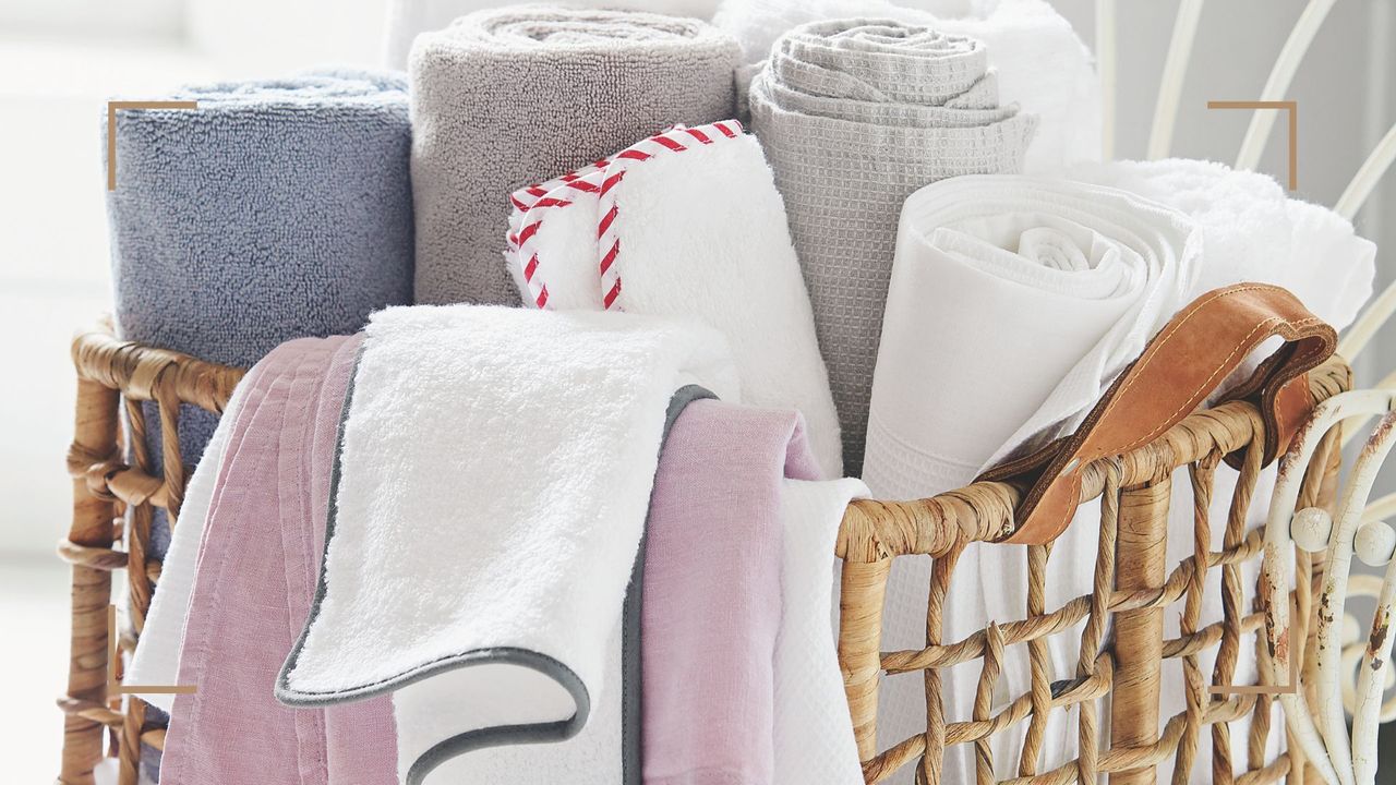 close up of a woven seagrass basket with rolled towels fresh from the airing cupboard