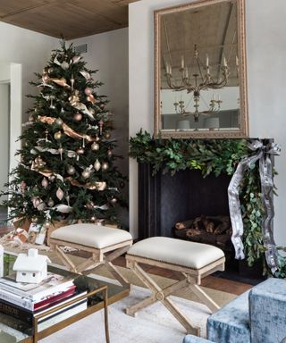 Grand living room decorated for the holidays with a christmas tree and green garland on the mantel