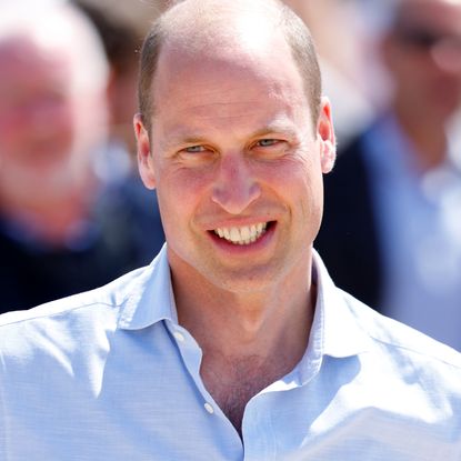 Prince William wears a light blue shirt with the top buttons undone