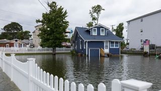 A blue house surrounded by flood water in North Beach, Maryland.
