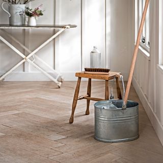 room with wooden flooring and wooden stool and cleaning mop stick