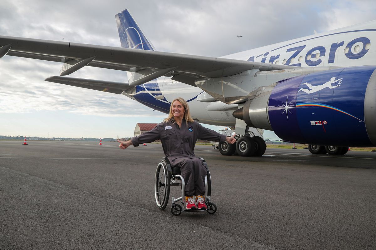 Sophie Morgan&#039;s Fight To Fly: Sophie Morgan sits in her wheelchair on the runway next to an aeroplane with the branding &quot;Air Zero&quot; on the sides. Sophie has both arms outstretched and both thumbs up.