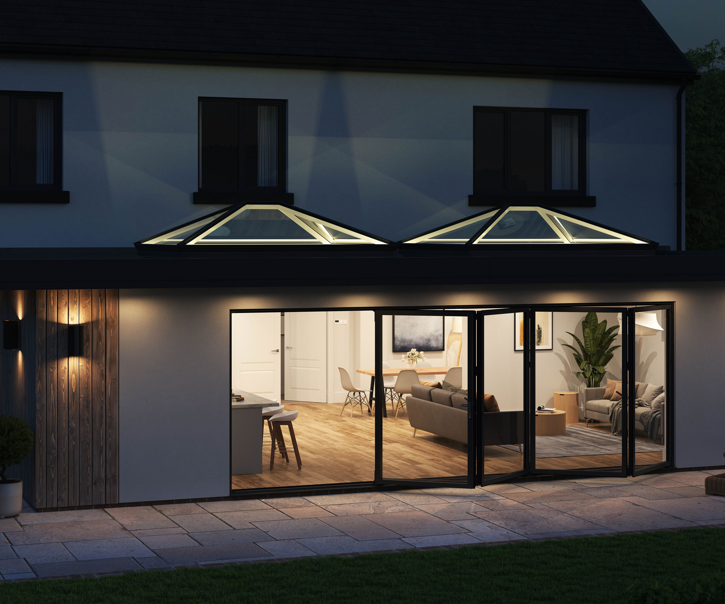 Large contemporary extension on back of house with illuminated rooflights and lit living space with large expanse of bifold doors