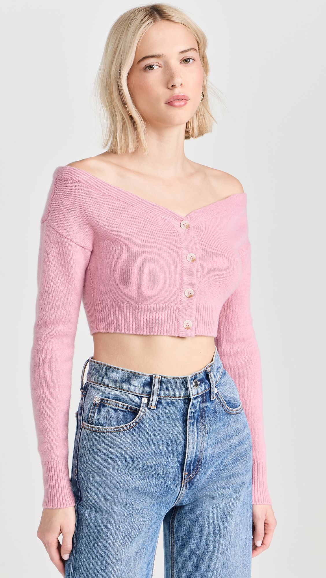 a model wears an off-the-shoulder pink cropped cardigan