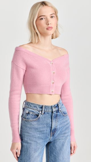 a model wears an off-the-shoulder pink cropped cardigan