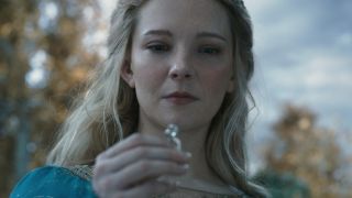 Morfydd Clark as Galadriel holding up one of the elves' rings of power.