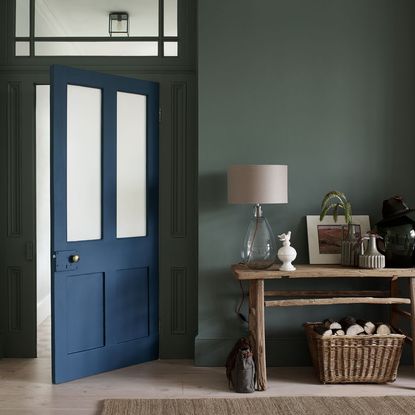 room with glass lamp wooden table and blue door