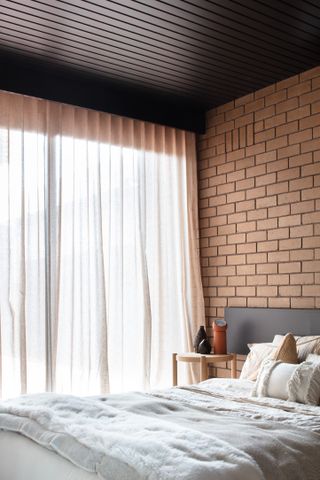 A bedroom with a brick accent wall