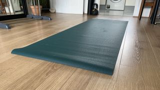 Jade Harmony yoga mat rolled out on wooden floor, ready for testing