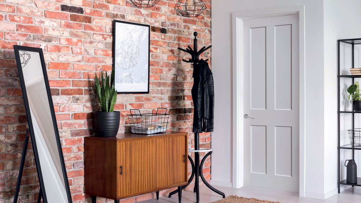 entrance hall with white door with white architrave and exposed brick wall