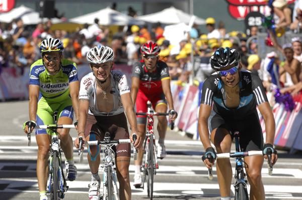 A group containing Ivan Basso and Andreas Kloden cross the line
