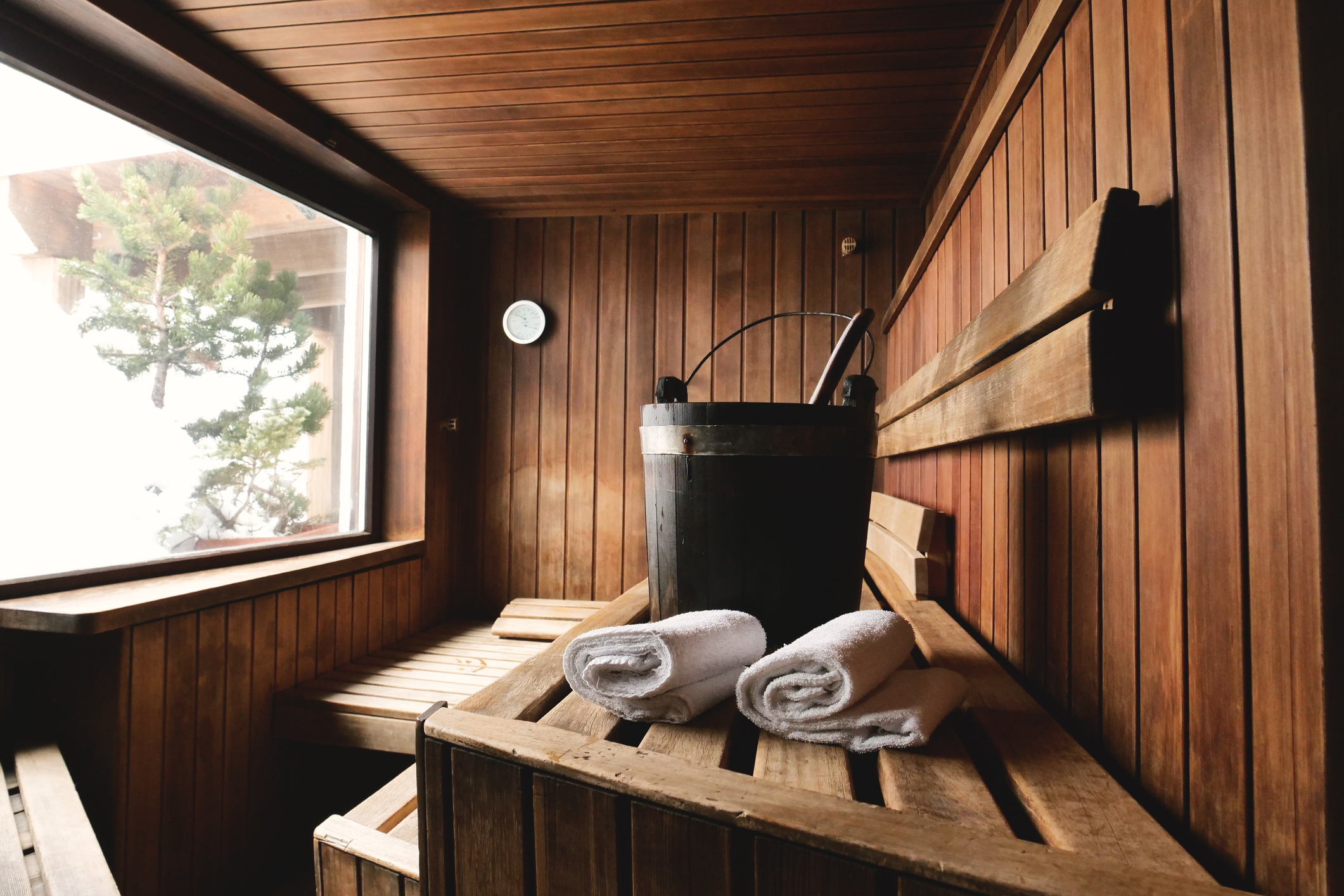 Interior of a rustic wood sauna with a large window.