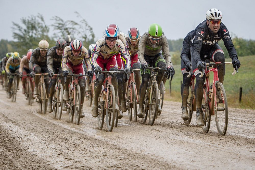 The peloton makes its way over one of todays sloppy mud roads