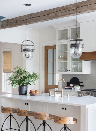A kitchen with vintage pendant lights and brass hardware