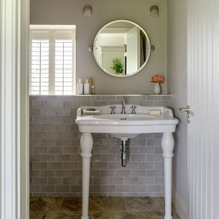bathroom with grey tile wall mirror and wash basin