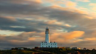 Lighthouse under a golden cloudy sky