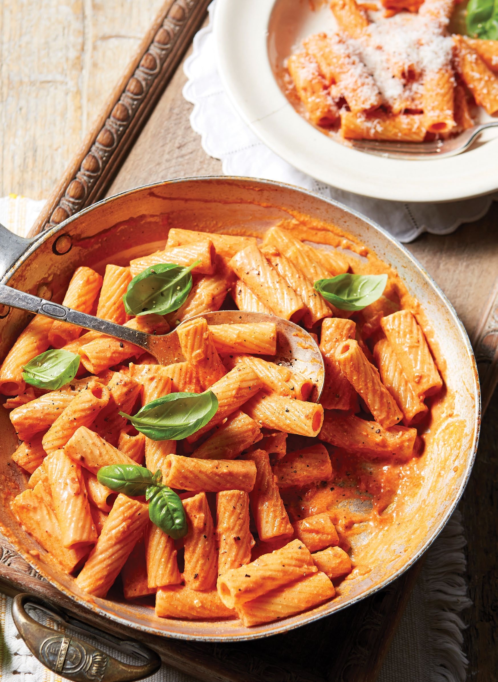 A plate of pasta with basil leaves on top