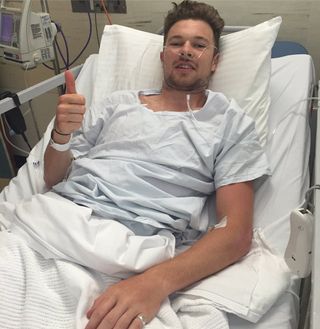 Owain Doull gives the thumbs up from his hospital bed