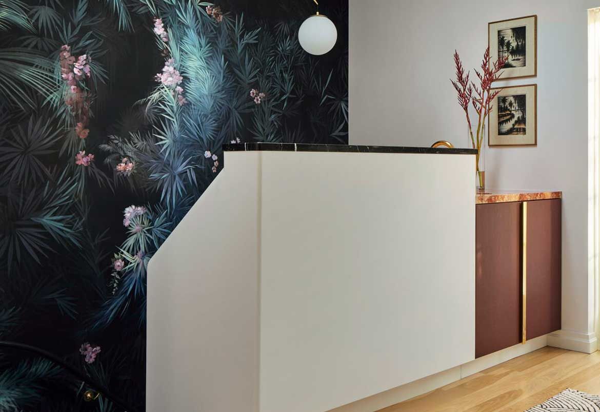 an upstairs hallway with wallpaper and a small bar