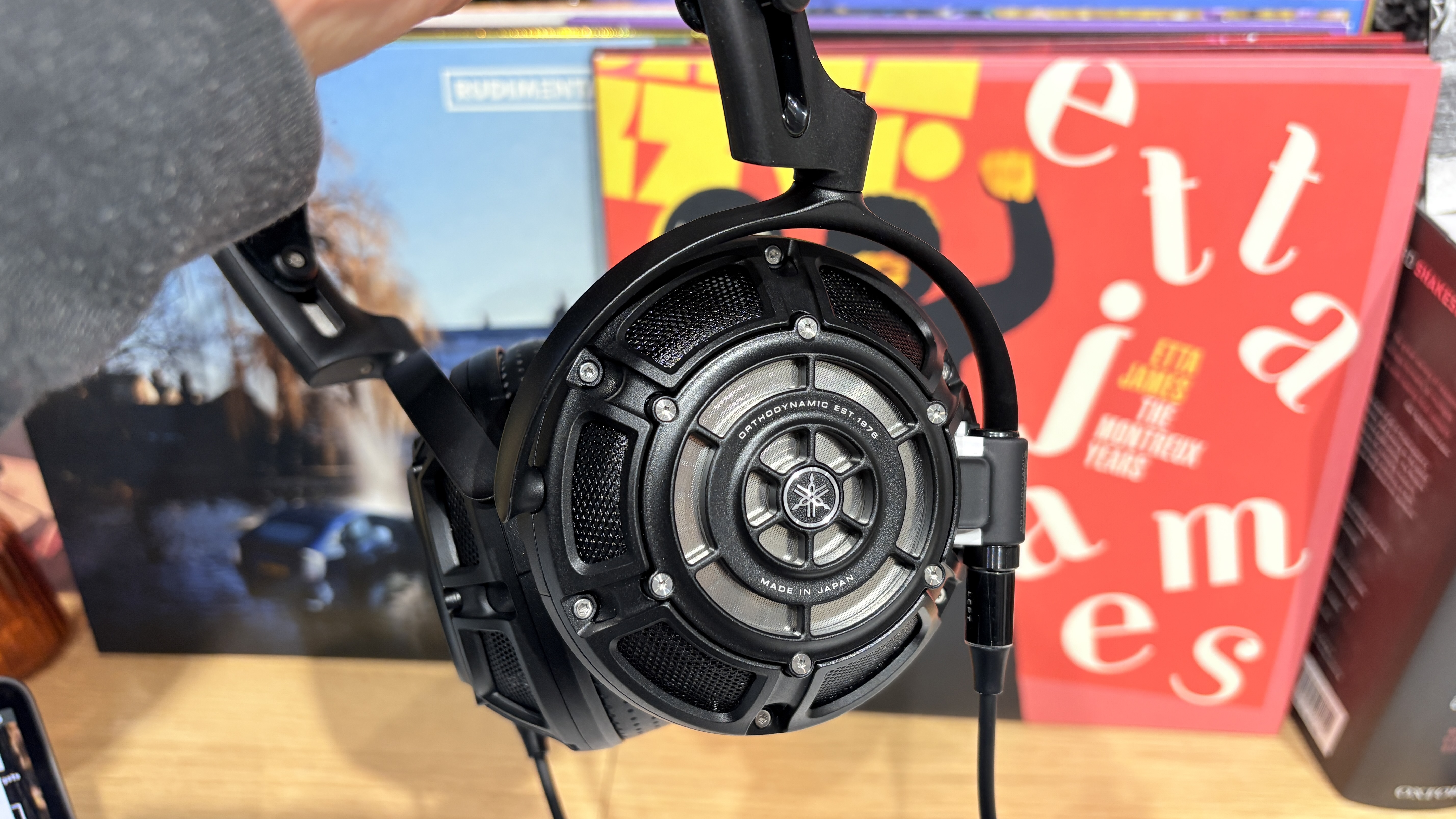 Yamaha YH-4000 headphones on desk against backdrop of colourful vinyl record albums