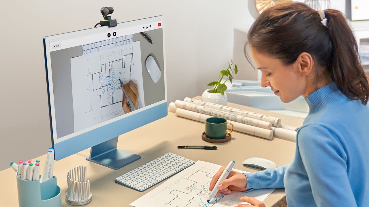 A person presenting in front of the Insta360 Link webcam