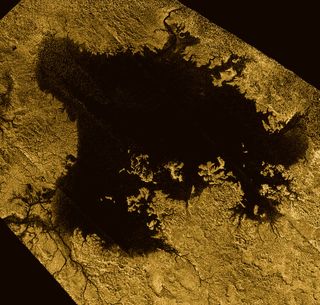 Data from the Cassini mission to Saturn show a large lake on Titan's surface. Liquid on the moon's surface is predominantly organic compounds like methane (shown in black here); the solid surface is made of water ice (shown in gold here).