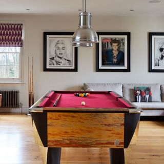 funky games room with bright pool table and iconic wall art