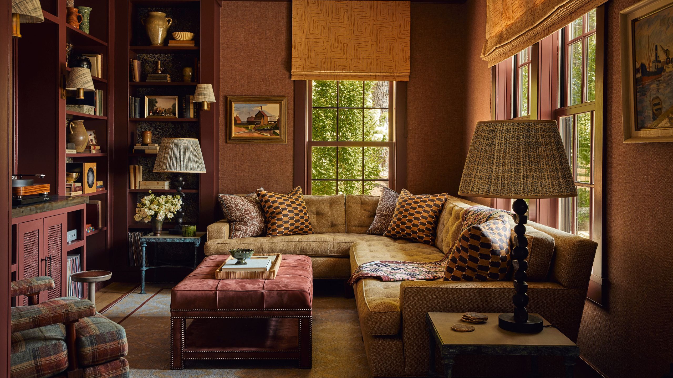 a large yet cozy snug room painted a deep purple, with a corner section, library shelving built around a TV