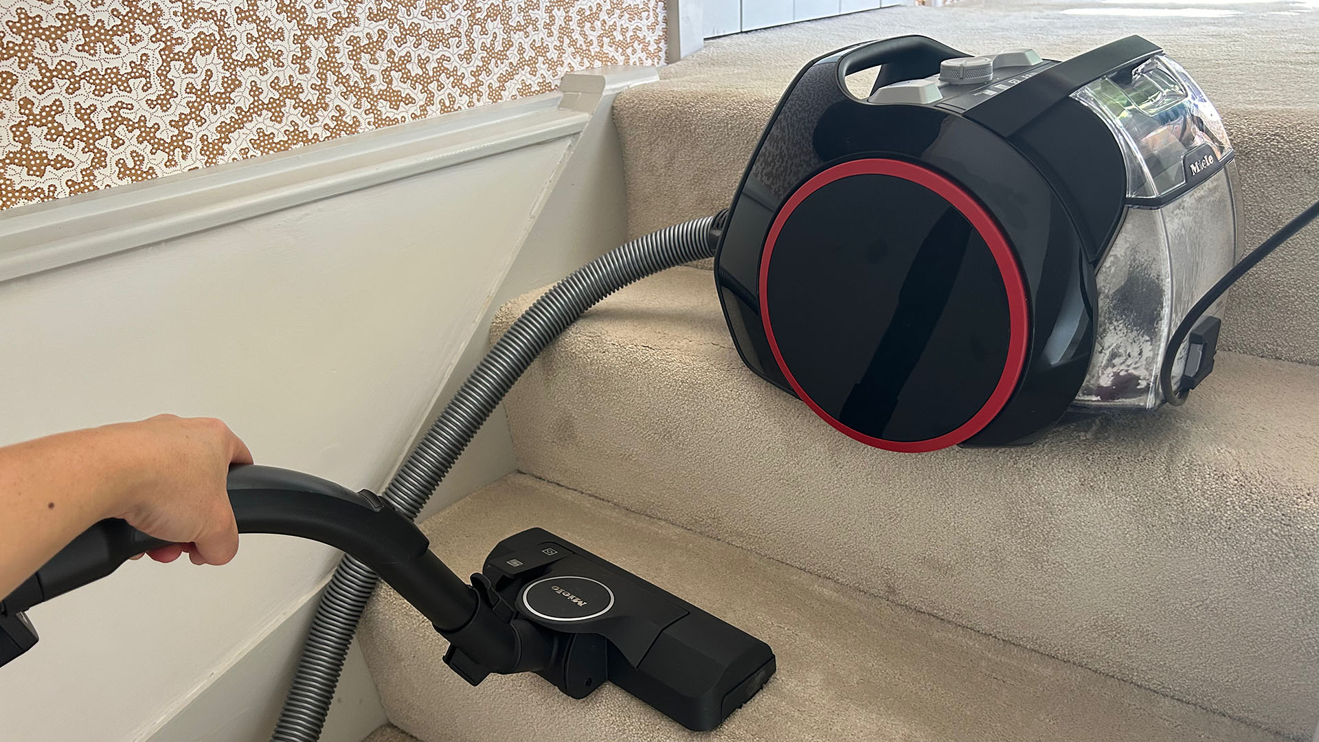 Miele Boost CX1 vacuum cleaner being used on carpeted stairs