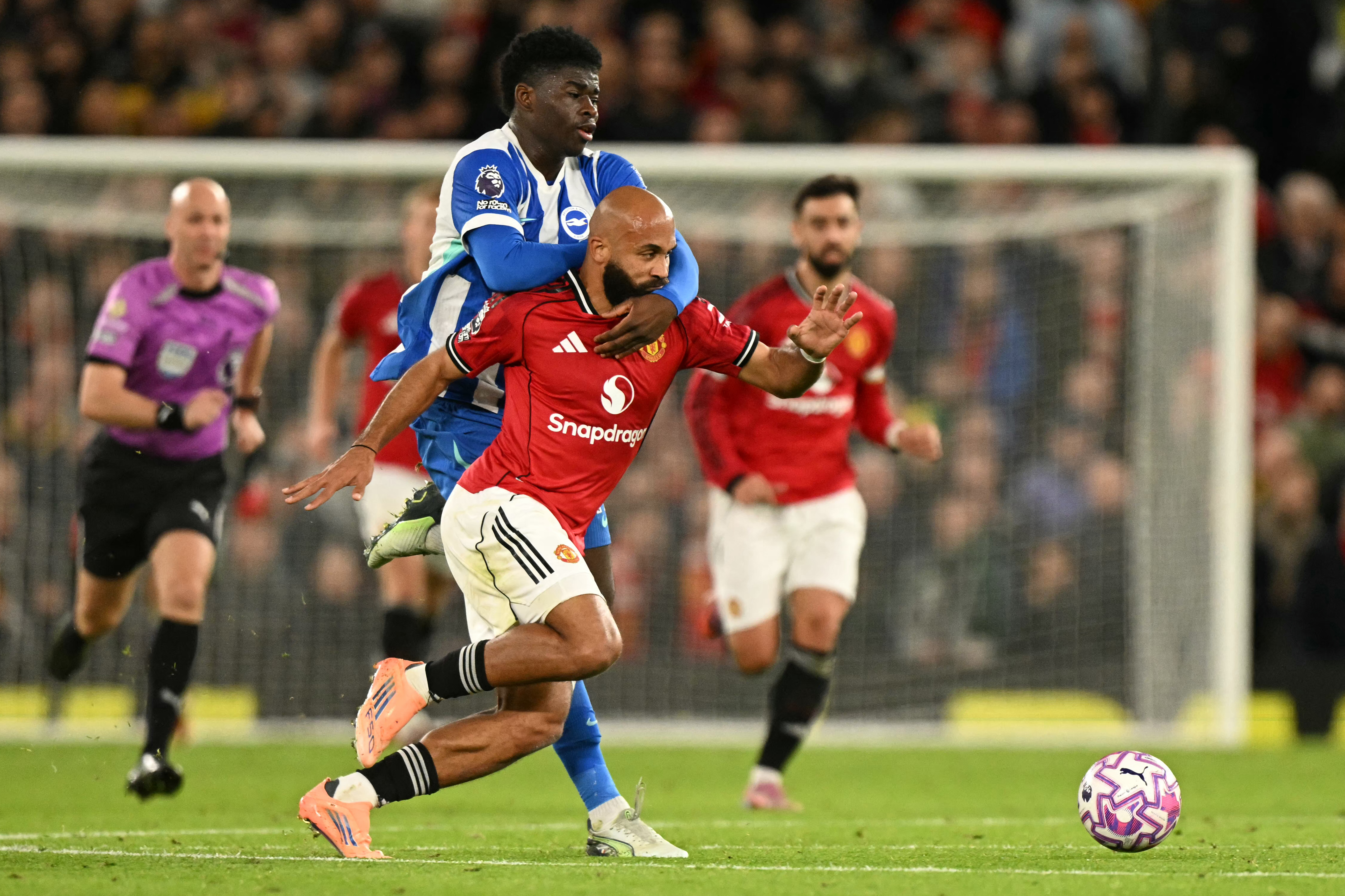 Brighton's Cameroonian midfielder #17 Carlos Baleba (L) fouls Manchester United's Cameroonian midfielder #19 Bryan Mbeumo (R) during the English Premier League football match between Manchester United and Brighton and Hove Albion at Old Trafford in Manchester, north west England, on October 25, 2025. (Photo by Oli SCARFF / AFP) / RESTRICTED TO EDITORIAL USE. No use with unauthorized audio, video, data, fixture lists, club/league logos or 'live' services. Online in-match use limited to 120 images. An additional 40 images may be used in extra time. No video emulation. Social media in-match use limited to 120 images. An additional 40 images may be used in extra time. No use in betting publications, games or single club/league/player publications. /