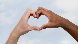 Two people holding their hands to form a heart shape