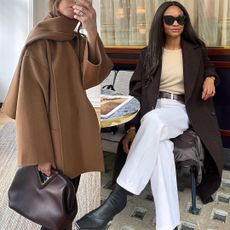 style influencers Johanna Piispa and Lorna Humphrey poses in chic winter 2025 2026 outfit ideas featuring a camel scarf coat, burgundy bag, brown coat, butter yellow sweater, brown belt, white jeans, and black square-toe boots